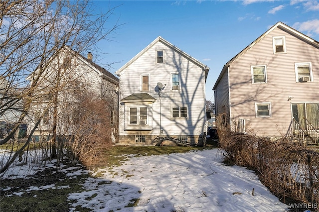 view of snow covered back of property