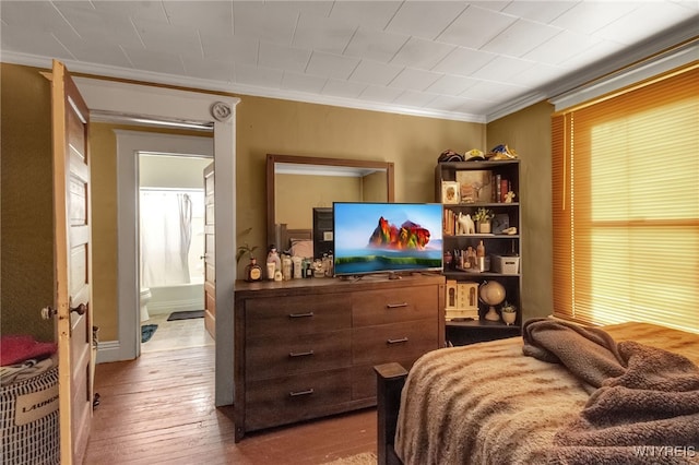 bedroom with hardwood / wood-style floors and crown molding