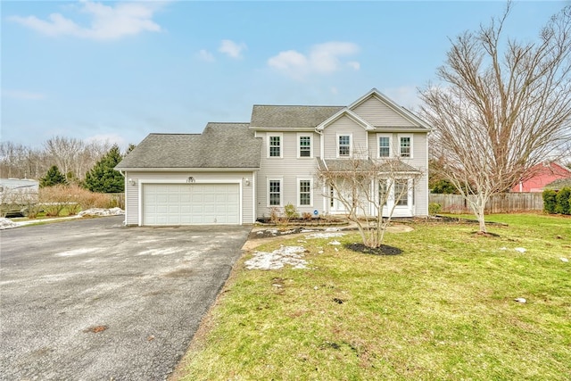 view of front of house with aphalt driveway, a front lawn, fence, and a garage