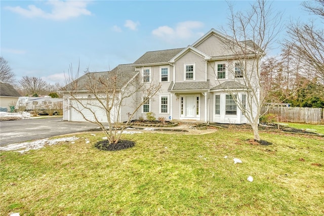 view of front of property with a garage, driveway, a front lawn, and fence