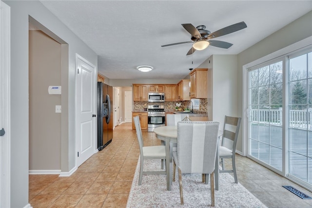 dining area with light tile patterned floors, visible vents, baseboards, ceiling fan, and a textured ceiling