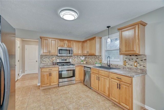 kitchen with stainless steel appliances, a sink, light countertops, and decorative backsplash