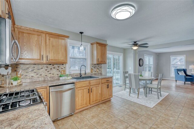 kitchen featuring a healthy amount of sunlight, stainless steel appliances, a sink, and light countertops