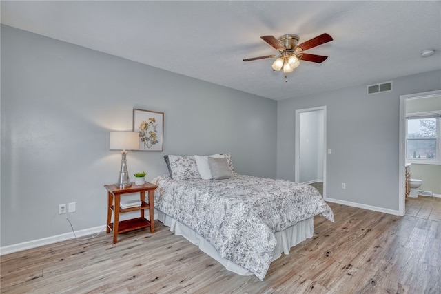 bedroom with light wood finished floors, visible vents, and baseboards