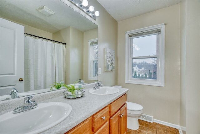 bathroom with a healthy amount of sunlight, visible vents, and a sink