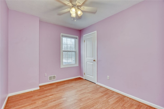 spare room featuring baseboards, a ceiling fan, visible vents, and light wood-style floors