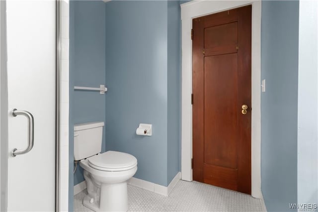 full bathroom featuring tile patterned floors, toilet, and baseboards