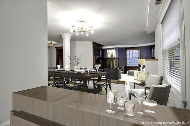 dining space with visible vents, decorative columns, and a notable chandelier