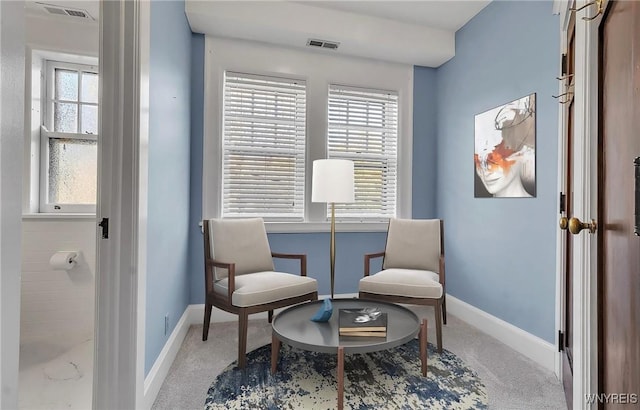 sitting room featuring visible vents, carpet, a wealth of natural light, and baseboards