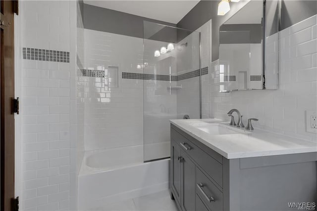 bathroom featuring  shower combination, decorative backsplash, tile walls, and vanity