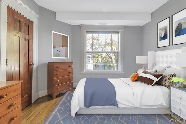 bedroom with dark wood-type flooring and baseboards