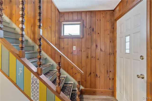 entrance foyer with wood walls and stairway