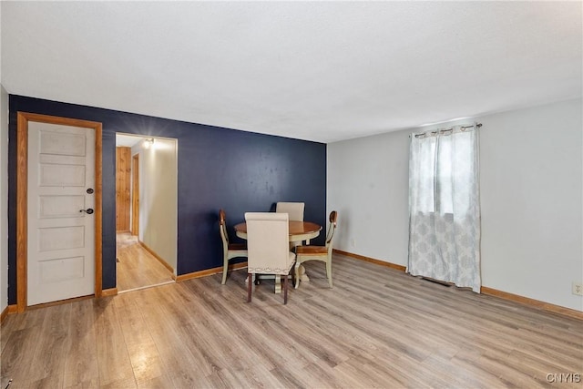 dining room featuring baseboards and light wood-style floors