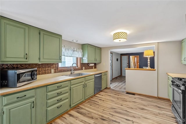 kitchen with light wood finished floors, light countertops, appliances with stainless steel finishes, and a sink