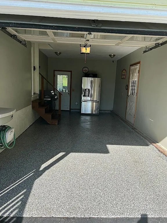 7429 Cherry Street Rd, Sennett, NY 13021 - garage featuring a garage door opener and stainless steel fridge