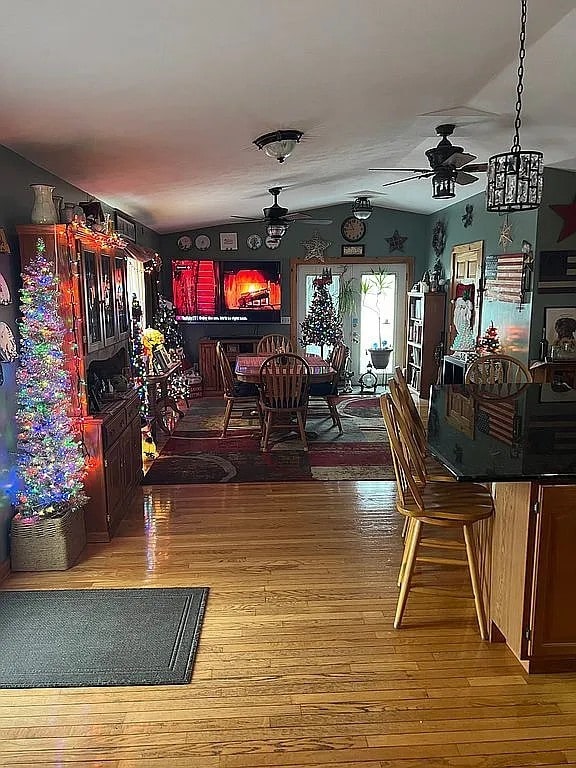 dining area featuring vaulted ceiling, ceiling fan, and wood finished floors