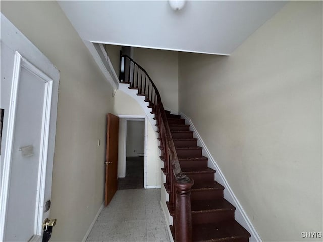 staircase featuring tile patterned floors and baseboards