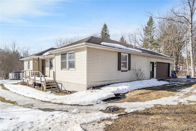 view of snow covered exterior featuring a garage