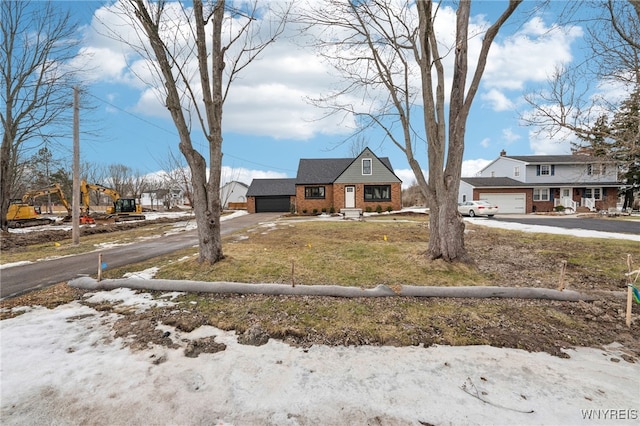 view of front of property with a garage, brick siding, and driveway