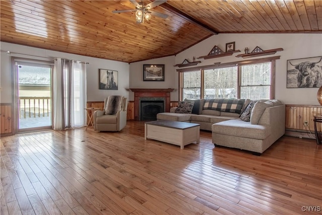 living area with vaulted ceiling with beams, light wood-style floors, and wood ceiling