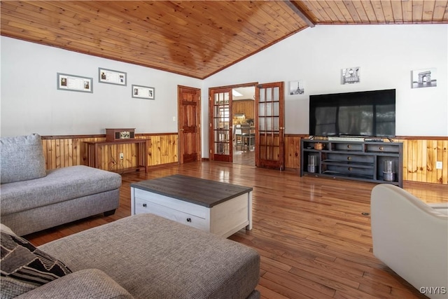 living room featuring a wainscoted wall, vaulted ceiling, wood walls, wooden ceiling, and hardwood / wood-style floors