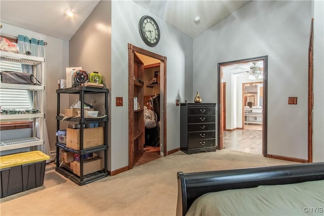 bedroom featuring a walk in closet, carpet, baseboards, and vaulted ceiling