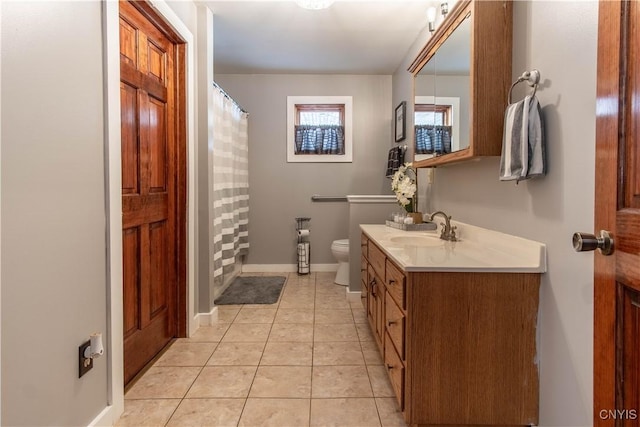 bathroom featuring a shower with shower curtain, toilet, vanity, baseboards, and tile patterned floors