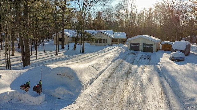 yard layered in snow featuring a detached garage