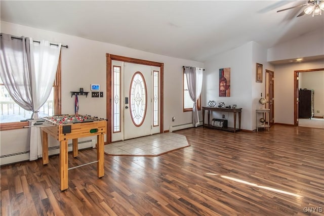 foyer entrance with vaulted ceiling, baseboard heating, wood finished floors, and a wealth of natural light