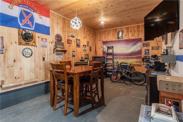 dining space featuring wood ceiling, concrete floors, and wooden walls