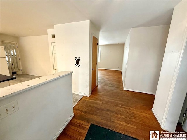 corridor with wood finished floors and baseboards