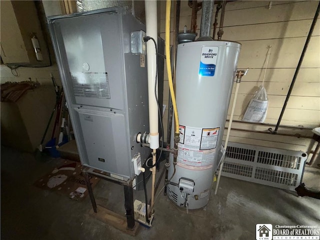 utility room featuring heating unit and gas water heater