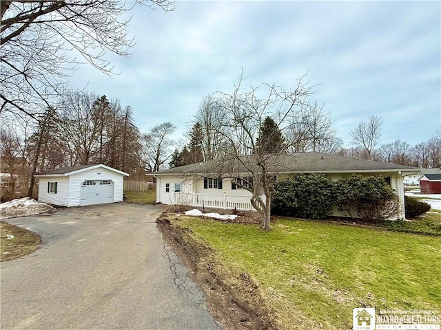 ranch-style house featuring an outbuilding, driveway, a front lawn, and a garage