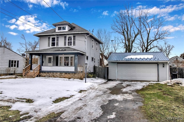 traditional style home with a porch, an outdoor structure, fence, and a detached garage