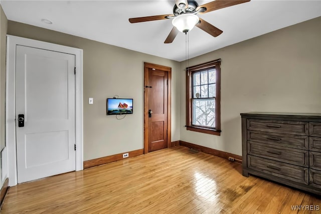 unfurnished bedroom featuring light wood-style floors, ceiling fan, and baseboards