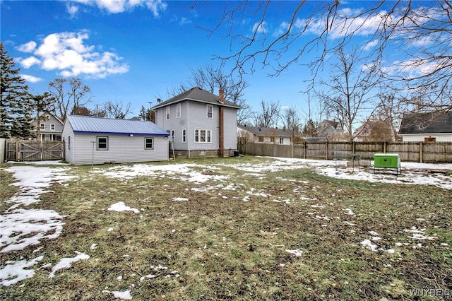 snow covered property featuring a fenced backyard and a chimney