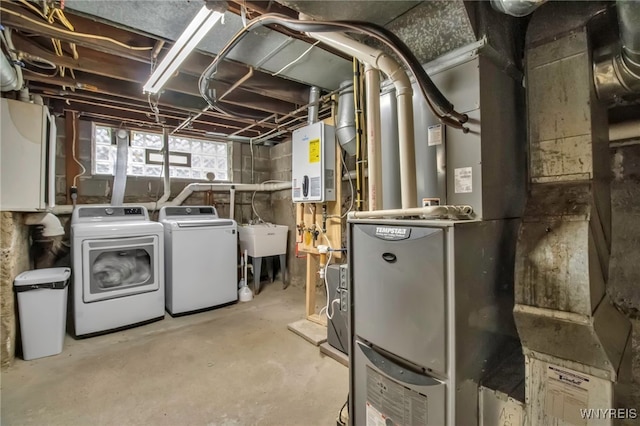 below grade area featuring tankless water heater, independent washer and dryer, and a sink