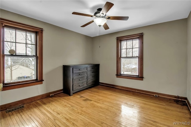 unfurnished bedroom with light wood-style floors, baseboards, visible vents, and a ceiling fan