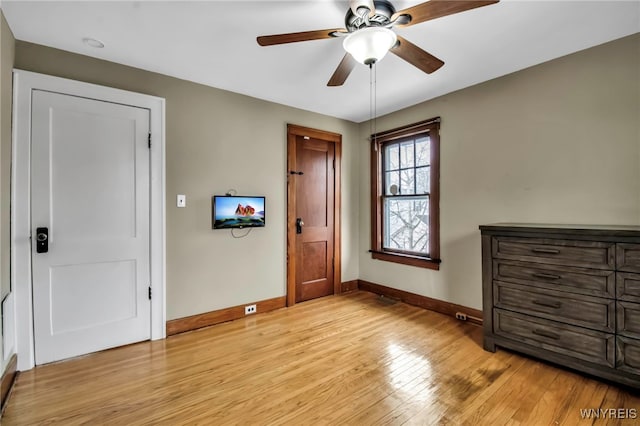 unfurnished bedroom featuring light wood finished floors, ceiling fan, and baseboards