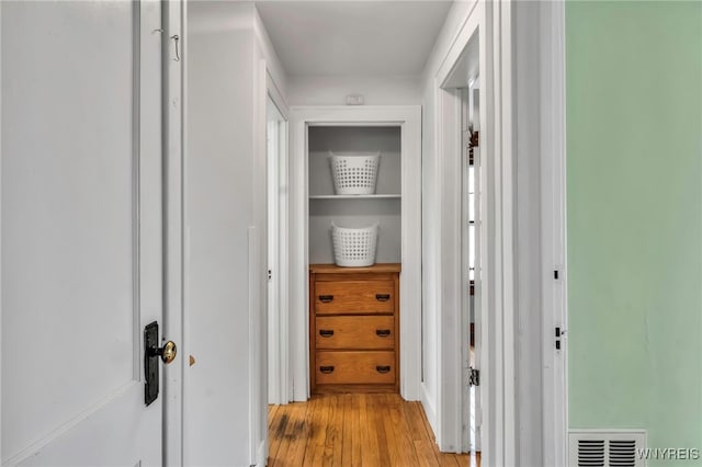 hallway featuring light wood-type flooring and visible vents