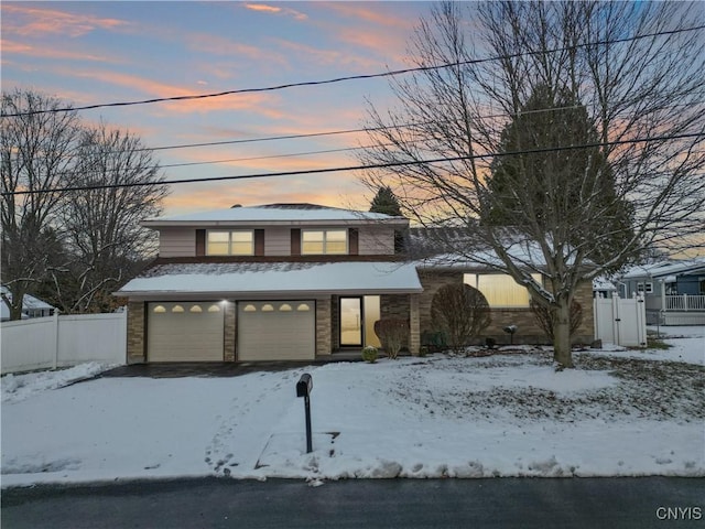 view of front of house with a garage, stone siding, and fence