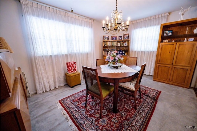 dining area with a chandelier, light carpet, and a healthy amount of sunlight