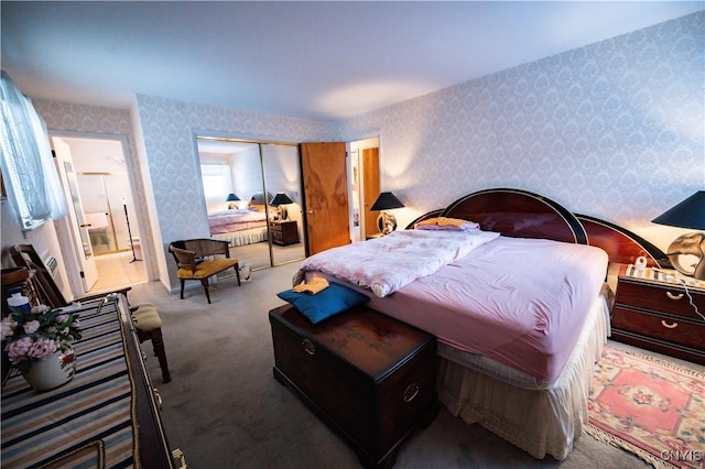 bedroom with ensuite bathroom, a closet, carpet, and wallpapered walls