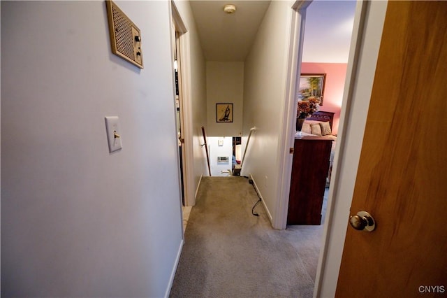 hall featuring light carpet, visible vents, and baseboards