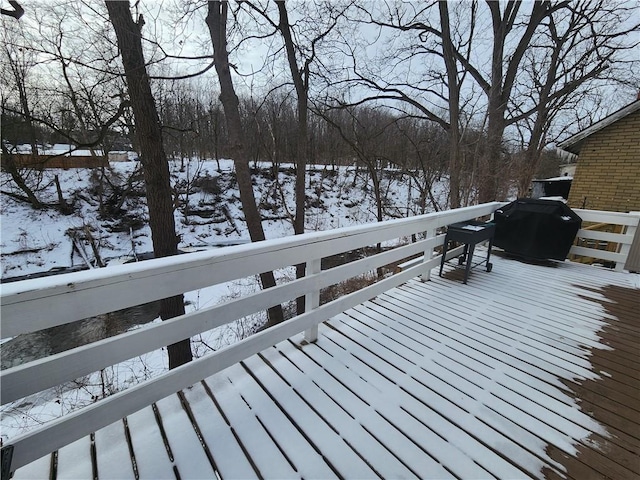 snow covered deck with a grill