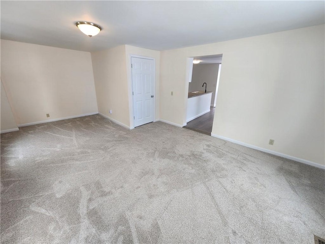 unfurnished room featuring carpet floors and baseboards