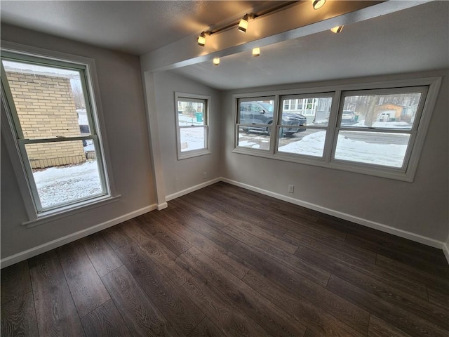 unfurnished room with lofted ceiling, dark wood finished floors, and baseboards