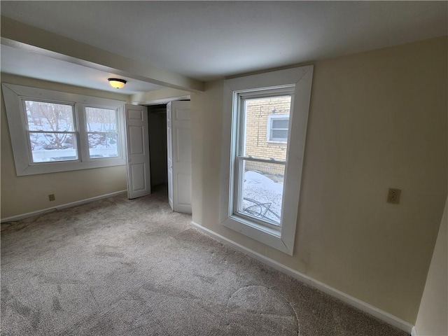 unfurnished bedroom with light carpet, baseboards, and a closet