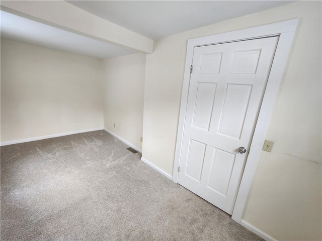 carpeted empty room featuring visible vents and baseboards