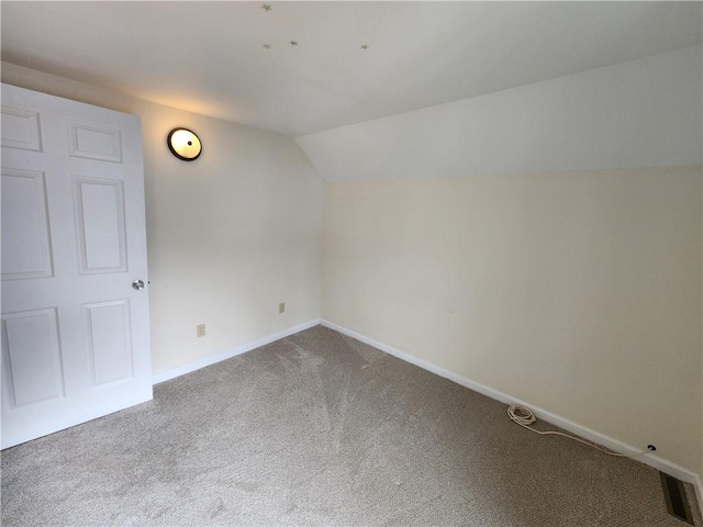 additional living space with carpet floors, visible vents, baseboards, and lofted ceiling